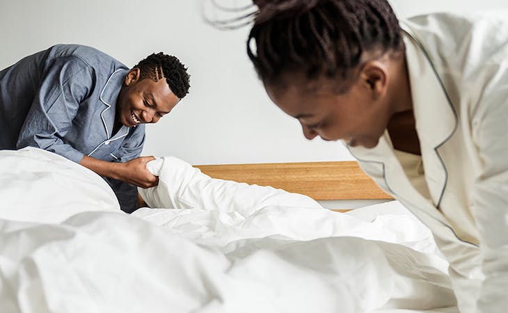 image of woman making bed in the morning