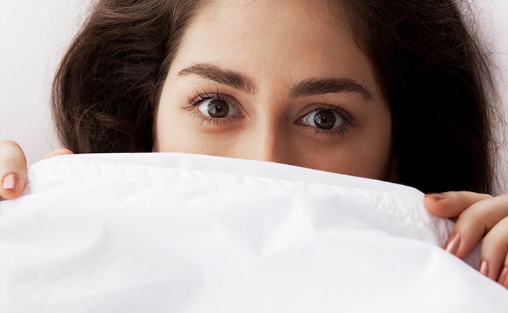 how to deal with acid reflux at night - image of woman under covers in bed
