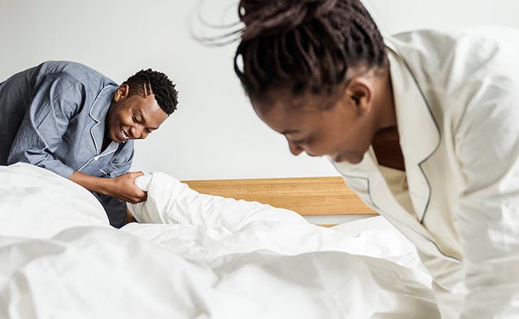 image of couple making bed -best mattress for couples