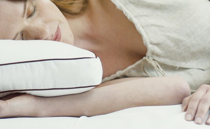 image of woman sleeping on side with pillow