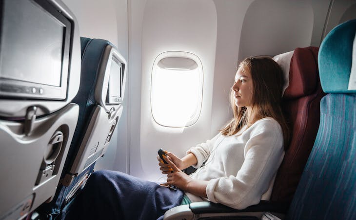 best and worst cures for jet lag - image of person sitting on airplane