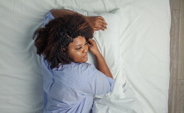 combination sleeper lying on side on mattress