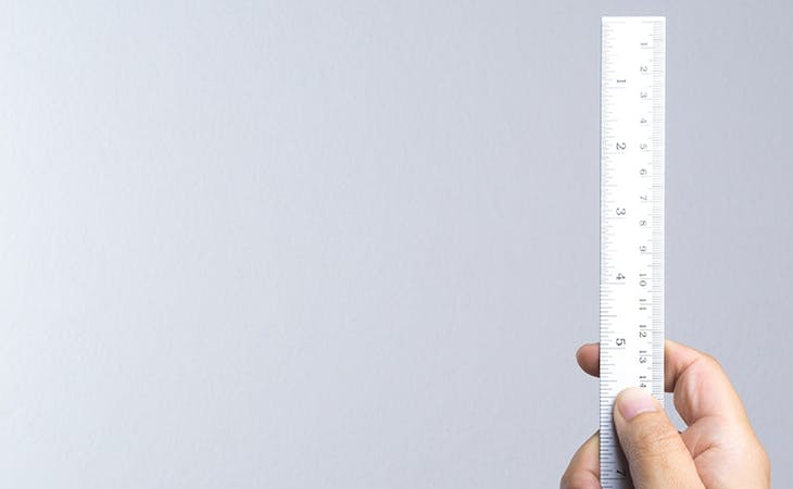 image of man holding ruler - mattress height