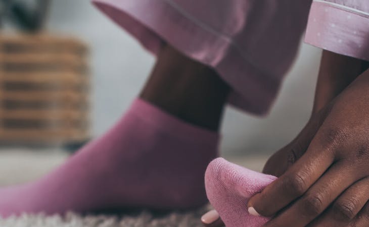 image of person touch foot in socks