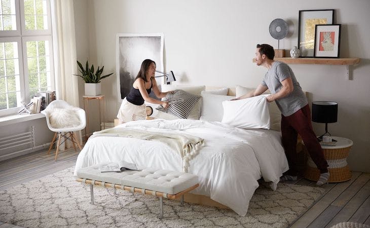 couple making bed together