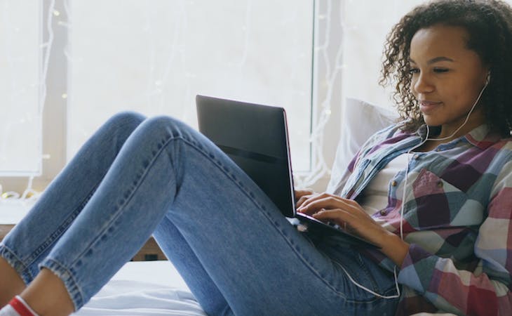 image of person video chatting with friends from bed