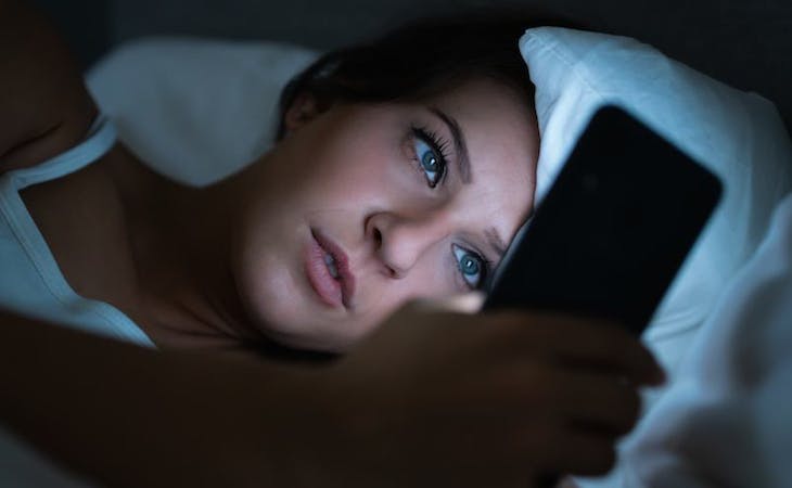 image of person on social media in bed
