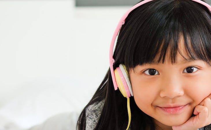 image of child listening to music in bed