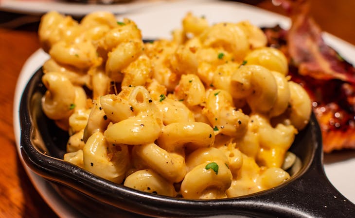 macaroni in a skillet and bacon on plate