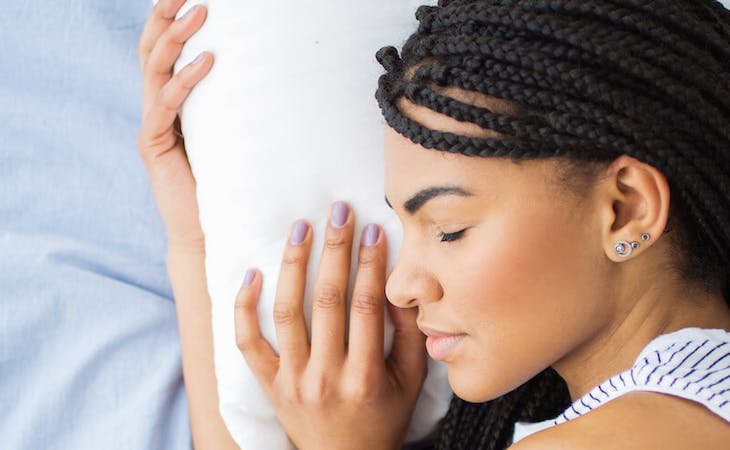 best pillow for health - image of person hugging pillow in bed