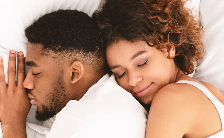 best sex pillow - image of couple cuddling in bed