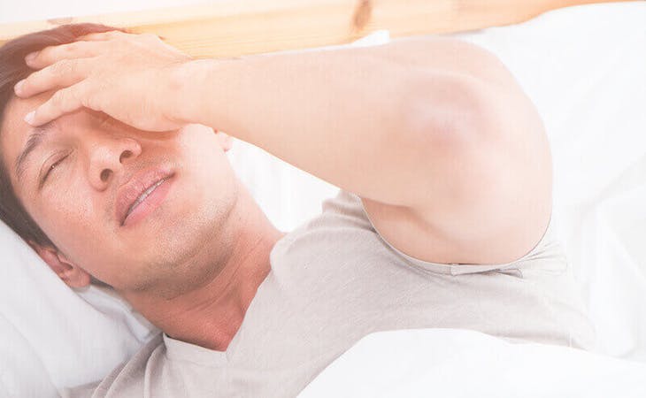 signs you need new mattress - person uncomfortable in bed