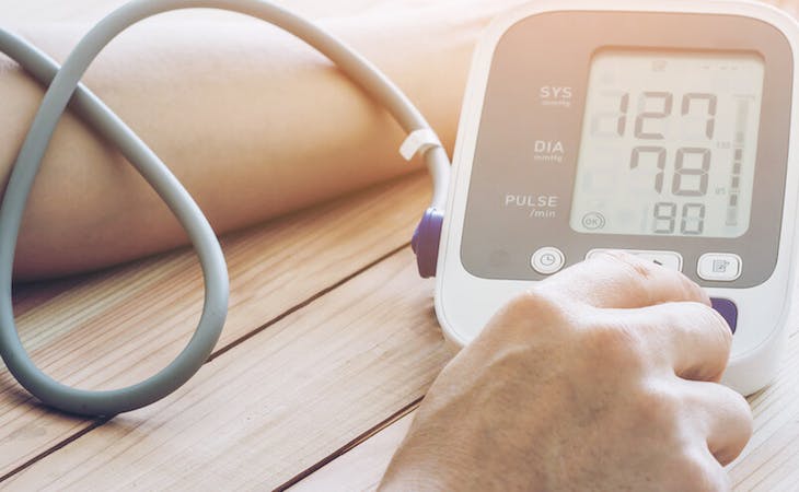 person using blood pressure monitor