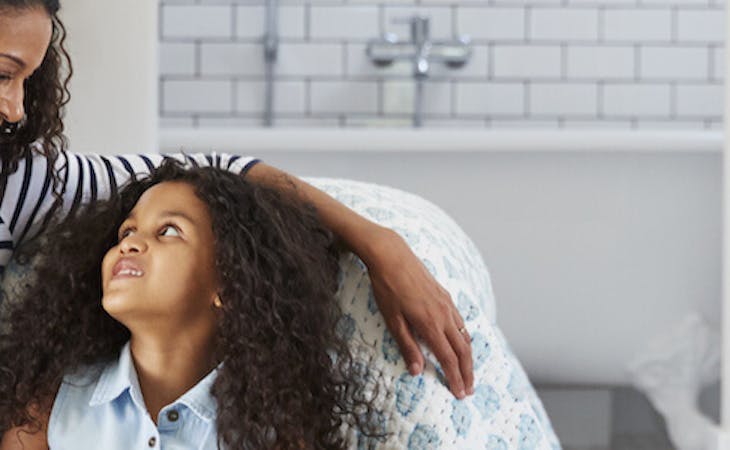 image of mom and child sitting on floor next to bed