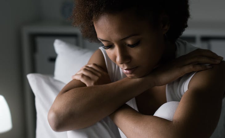 racism and sleep - image of worried person sitting up in bed