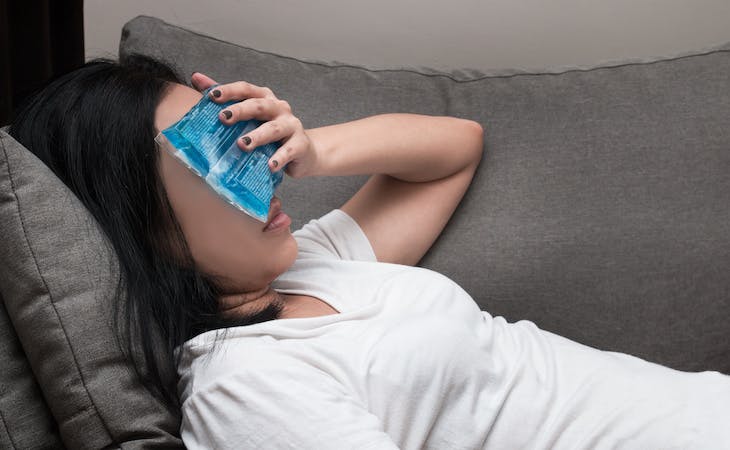 person with ice pack over face to cool down from night sweats