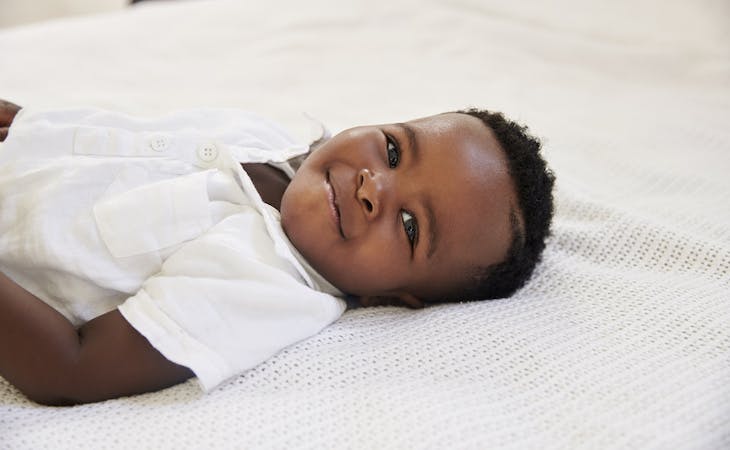 toddler lying on bed