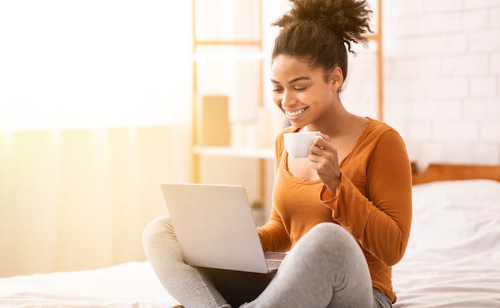 person drinking coffee in bed in the morning