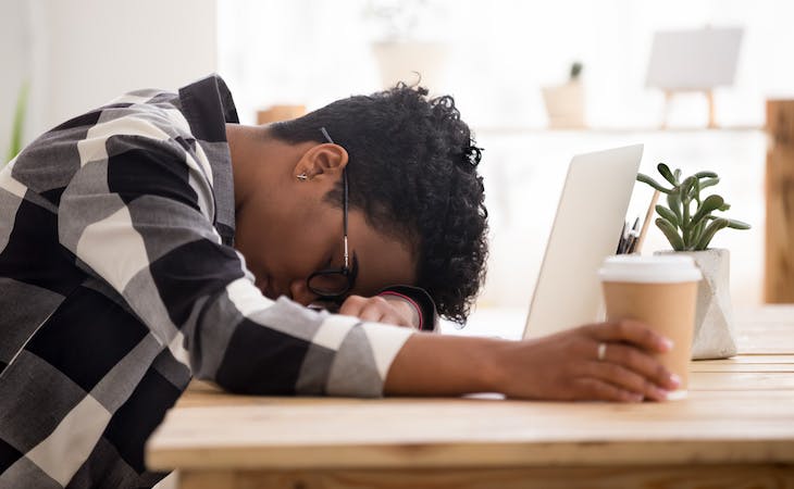 person with sleep disorder sleeping with head down on desk