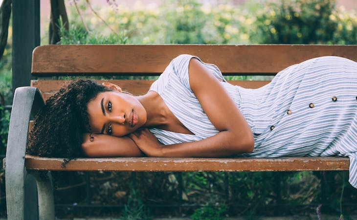 person lying on bench outside in the summer