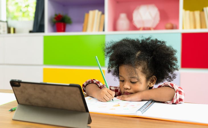 child at school writing in notebook