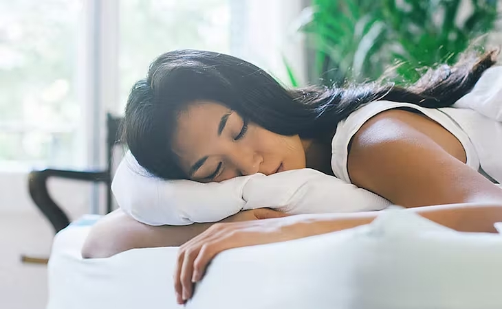 woman lying down on white pillow