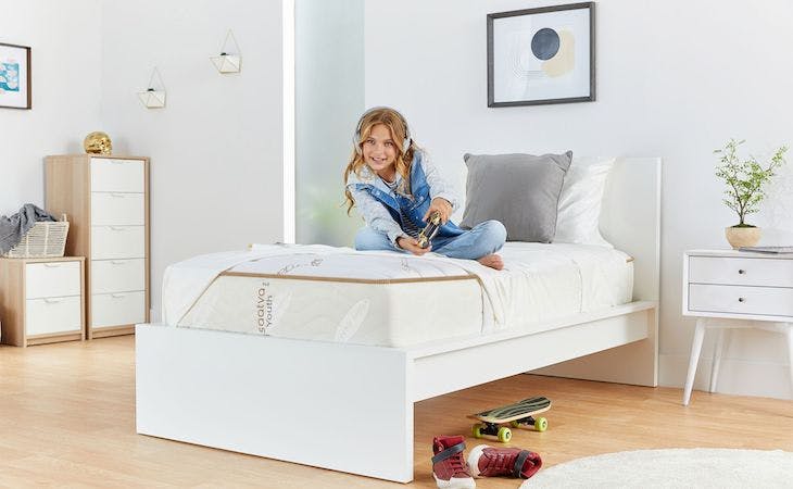 child sitting on mattress playing video games in luxury kids bedroom