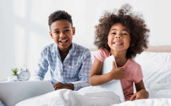 siblings in bed with laptops