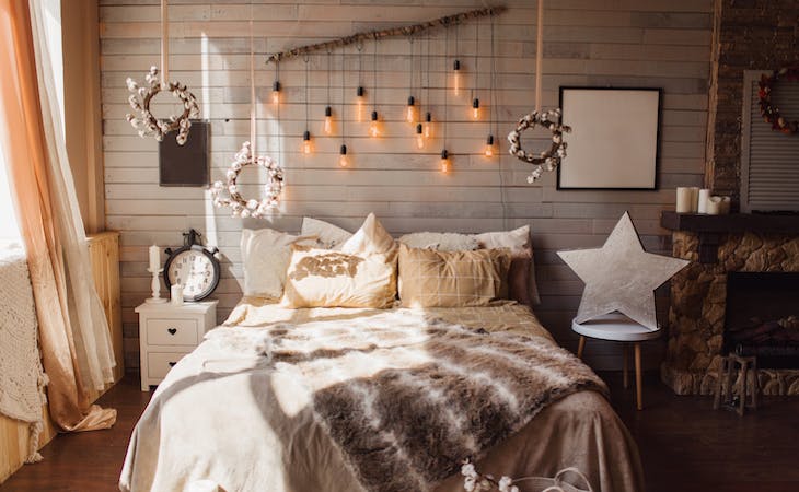 cozy bedroom with blankets, lights, and decor