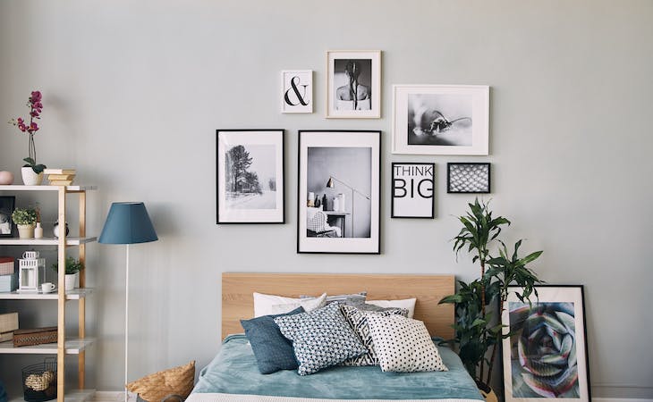 bedroom with art hanging on wall above bed