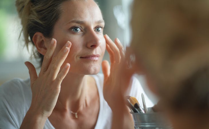 person with dark circles looking in mirror