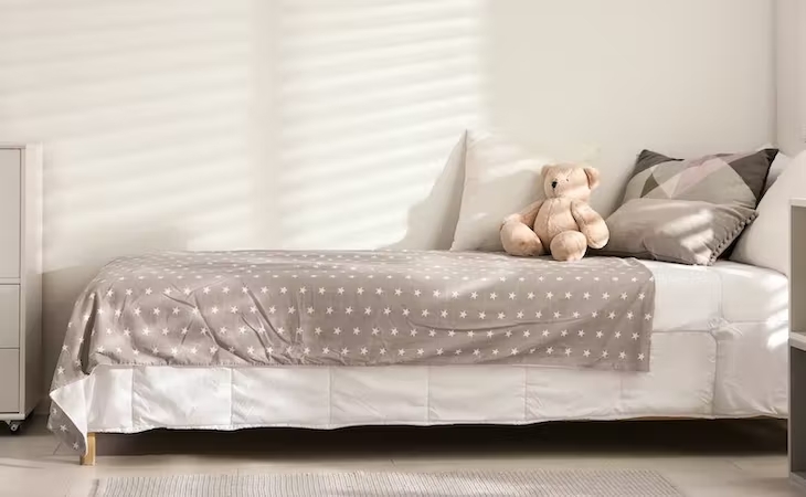 Children's bed with stuffed bear on top