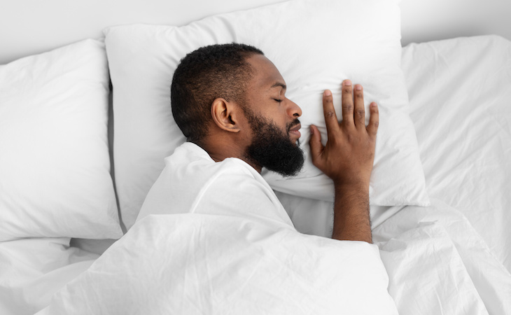 Man sleeping on side resting head on pillow