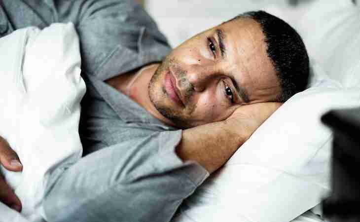 person lying awake experiencing restless sleep