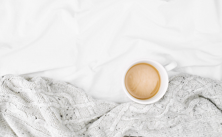 cup of coffee on top of bed