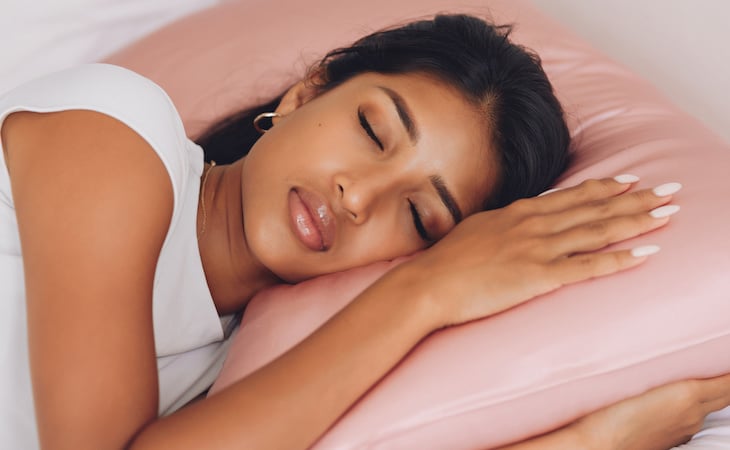 person lying on silk pillowcase to prevent sleep wrinkles