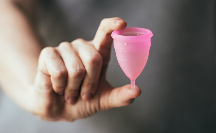 person holding menstrual cup in hand