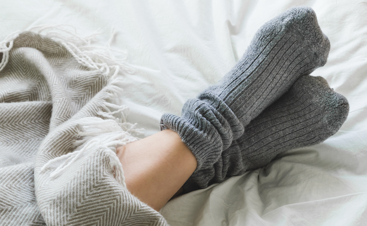 person with feet touching in bed