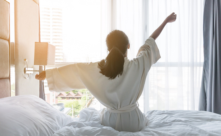 person waking up in a hotel room