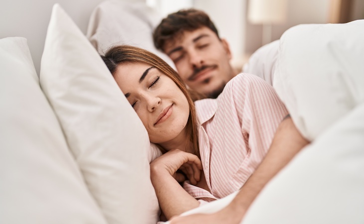 couple sleeping on a split queen mattress