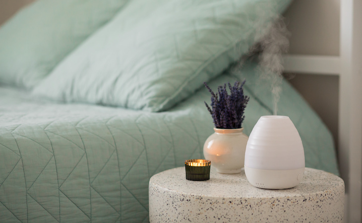 essential oil diffuser on table next to bed