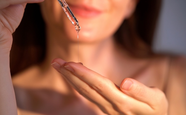 Woman applying glycolic acid serum with dropper