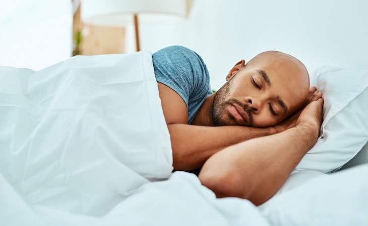 Man peacefully sleeping in bed.