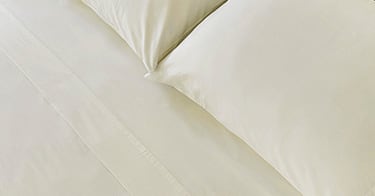 A made bed with Saatva sheets.