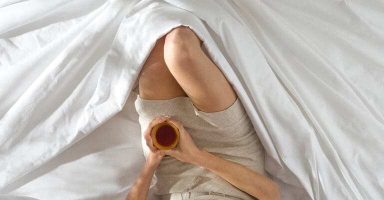 Woman lying comfortably in Saatva sheets.