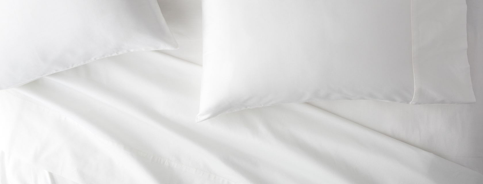 Saatva sheets and pillows on a bed.