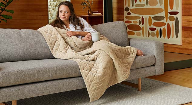 Woman wrapped comfortably in a weighted blanket.