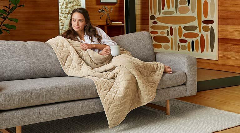 Woman wrapped comfortably in a weighted blanket.